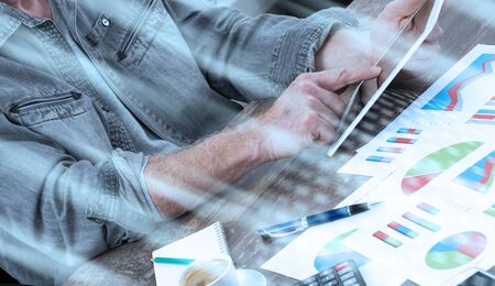 Businessperson analyzing financial charts with tablet computer; light effect