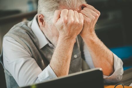 Stressed senior businessman sitting in officeの写真素材