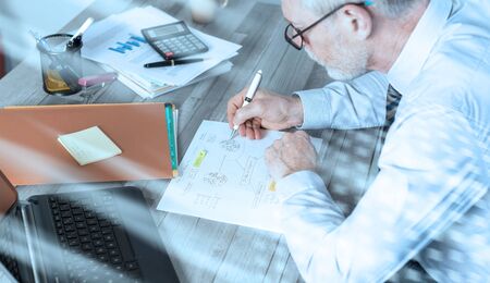 Mature businessman working on documents in office; light effectの写真素材