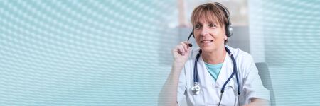 Portrait of mature female doctor during online medical consultation; panoramic bannerの写真素材