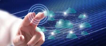 Woman touching a cloud networking concept on a touch screen with her finger