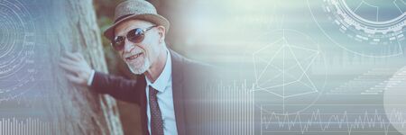 Portrait of mature man wearing sunglasses outdoors, light effect; panoramic bannerの写真素材