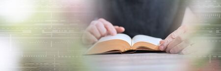 Man sitting and reading a book; panoramic banner