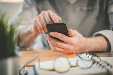 Male hands using mobile phoneの写真素材