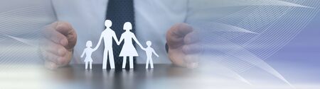 Insurer protecting a family with his hands; panoramic bannerの写真素材