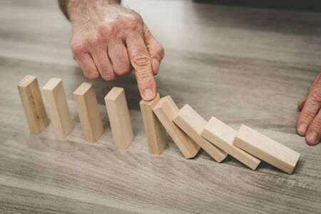 Business control concept by stopping domino effect