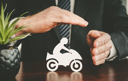 Insurer protecting a motorbike with his handsの写真素材