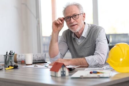 Portrait of senior architect sitting in office and looking at the cameraの写真素材