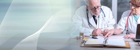 Two doctors discussing about medical results in clinic; panoramic bannerの写真素材