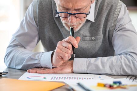 Businessman analysing marketing charts at officeの写真素材