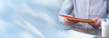 Businessman holding a folder at office; panoramic bannerの写真素材