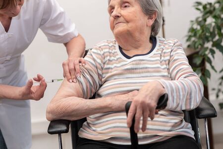 Nurse giving an injection to senior womanの写真素材