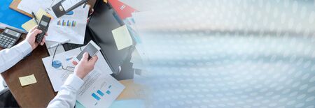 Businessman working at an untidy and cluttered desk; panoramic bannerの写真素材