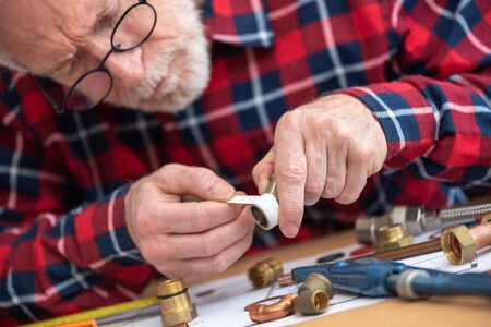 Plumber putting seal tape on a thread of a plumbing fittingの写真素材