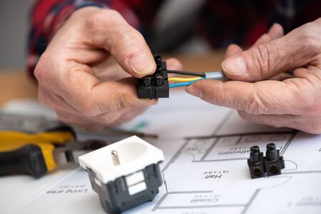 Electrician hands connecting wires in terminal blockの写真素材