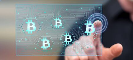 Man touching a bitcoin concept on a touch screen with his finger