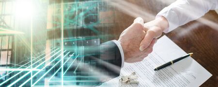 Estate agent shaking hands with his customer after contract signature; multiple exposureの写真素材