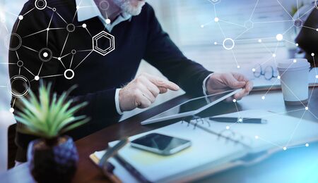 Senior businessman working on digital tablet at office; light effect