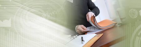 Businessman looking for document in folder at office; panoramic bannerの写真素材