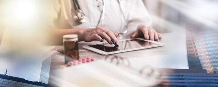Femaler doctor using digital tablet in medical office; multiple exposureの写真素材
