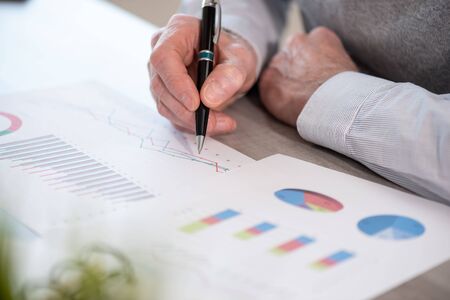 Businessman analysing marketing charts at officeの写真素材