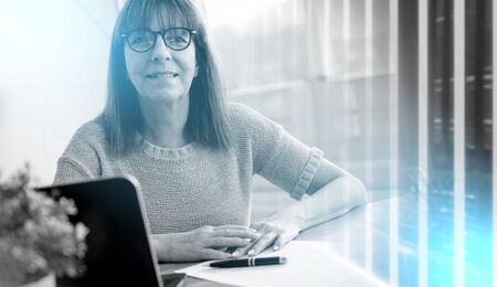 Portrait of mature businesswoman sitting at office; multiple exposureの写真素材