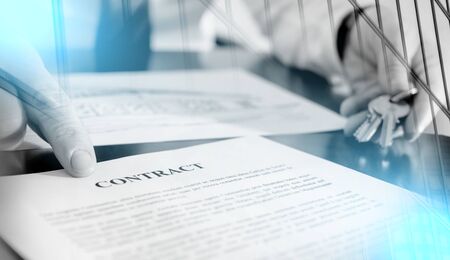 Realtor showing a contract with his finger; multiple exposureの写真素材