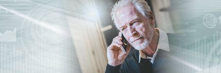 Portrait of senior modern man talking on mobile phone at home; panoramic bannerの写真素材