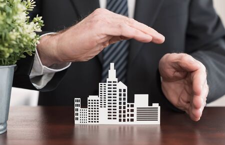 Insurer protecting an office building with his handsの写真素材