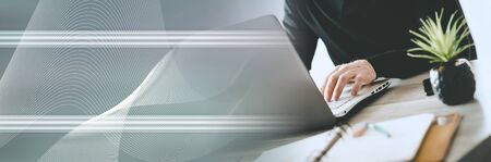 Businessman working on laptop in office; panoramic banner