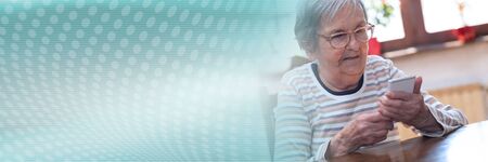 Elderly woman using a mobile phone; panoramic banner