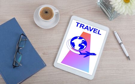 Top view of a desk with travel concept on a digital tabletの写真素材