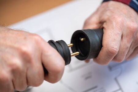 Electrician hands holding electrical plugs