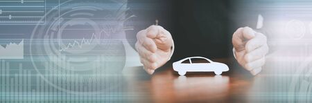 Insurer protecting a car with his hands; panoramic banner