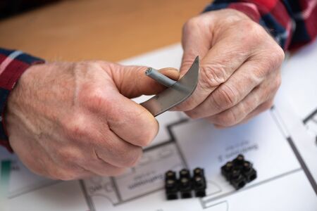 Electrician hands cutting the insulation of a power cable