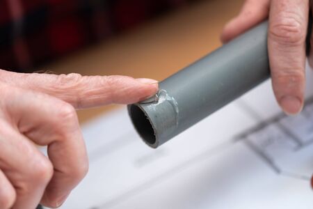 Plumber putting glue on a pvc pipeの写真素材
