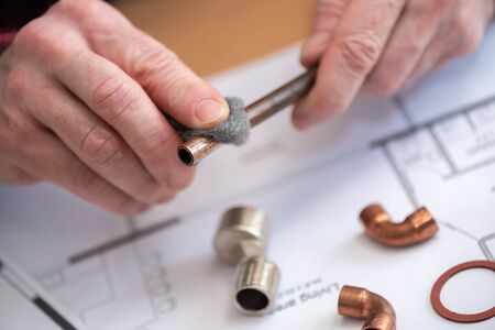 Plumber preparing a copper tube before welding