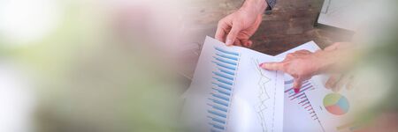 Team discussing about financial charts; panoramic banner