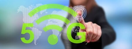 Woman touching a 5g concept on a touch screen with her fingerの写真素材