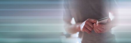 Man standing using his smartphone; panoramic bannerの写真素材