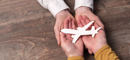 Concept of flight insurance with paper plane in handsの写真素材