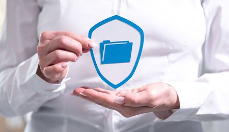 Concept of data protection with paper shield held by female handの写真素材