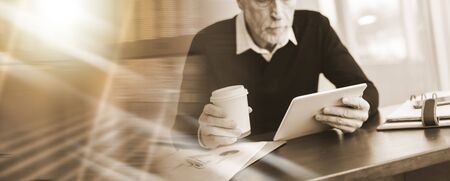 Senior businessman working on digital tablet at office; multiple exposure