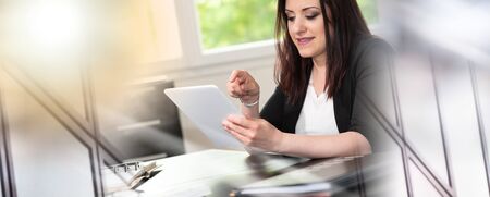 Businesswoman using digital tablet at workplace; multiple exposureの写真素材