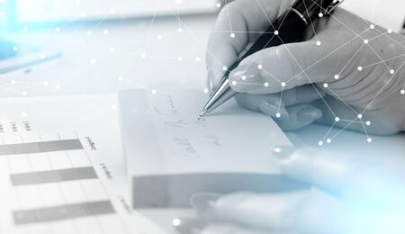 Businesswoman taking notes on a post-it; light effectの写真素材