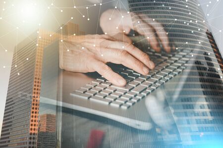 Businessman using laptop in office; multiple exposure