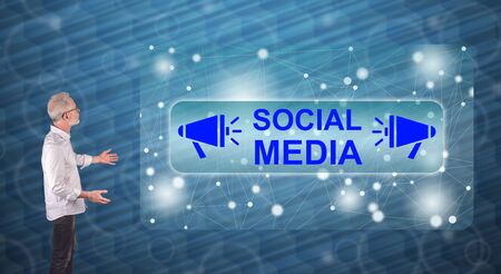 Businessman showing a social media concept on a wall screenの写真素材