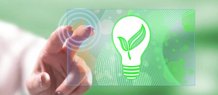 Woman touching a green energy concept on a touch screen with her fingerの写真素材