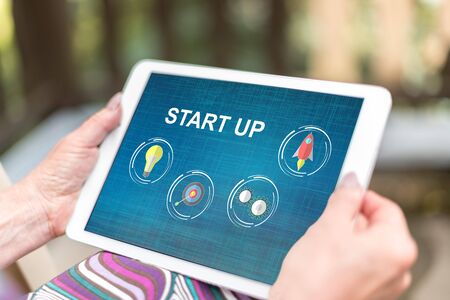 Female hands holding a tablet with start up conceptの写真素材