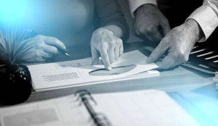 Coworkers working on financial statistics in office; light effect